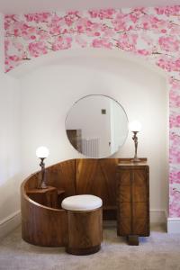 a bathroom with a wooden tub with a mirror at Sea-facing Art Deco Apartment in Brighton & Hove