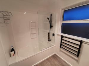 bagno bianco con doccia e finestra di Hello Seaview! 4 BRs House in Central Location! a Oamaru