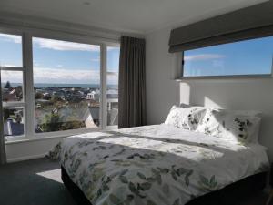 una camera da letto con un letto e una grande finestra di Hello Seaview! 4 BRs House in Central Location! a Oamaru