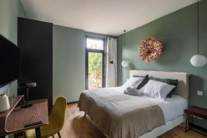 een slaapkamer met een bed, een tafel en een raam bij Maison Castellio by Cocoonr in Rennes