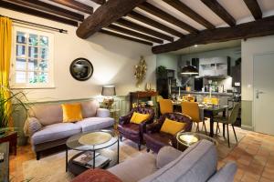 Il comprend un salon avec des canapés et des chaises ainsi qu'une cuisine. dans l'établissement Cottage Livingstone by Cocoonr, à Rennes