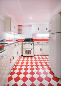 kuchnia z czerwono-białą podłogą wyłożoną szachownicą w obiekcie Sea-facing Art Deco Apartment w Brighton and Hove