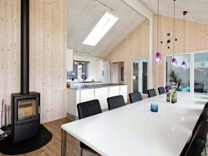 ボーゲンセにある16 person holiday home in Bogenseの暖炉、テーブル、椅子が備わる客室です。