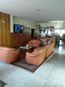 a living room with leather chairs and a tv at Manuela Residence in Lagos