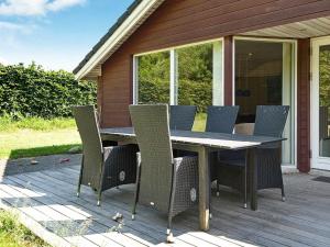 un patio con mesa y sillas en una terraza en 8 person holiday home in Juelsminde, en Sønderby