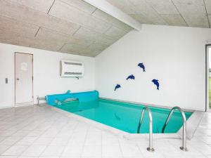 een zwembad in een kamer met dolfijnen aan de muur bij 12 person holiday home in Hj rring in Lønstrup