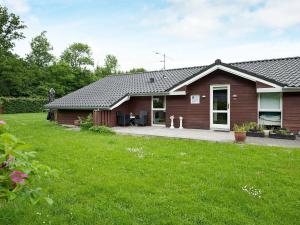 a brown house with a lawn in front of it at 8 person holiday home in Juelsminde in Sønderby