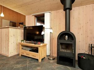 a living room with a fireplace with a tv and a stove at 8 person holiday home in Vejers Strand in Vejers Strand