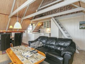 uma sala de estar com um sofá de couro e uma mesa em 6 person holiday home in Ringk bing em Klegod