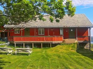 a red house with two picnic tables in front of it at Four-Bedroom Holiday home in Follafoss in Vølset