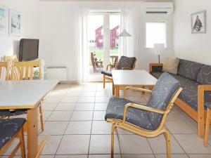 sala de estar con sofá, mesa y sillas en Holiday Home Havblik II, en Øster Hurup