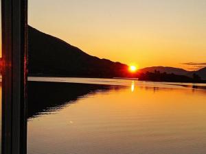 een zonsondergang boven een waterlichaam met zonsondergang bij 11 person holiday home in Gullesfjord in Flesnes