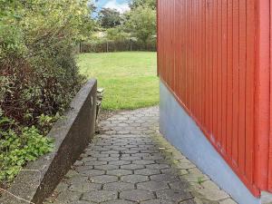 una pasarela de ladrillo junto a una valla roja en 30 person holiday home in Nordborg, en Nordborg