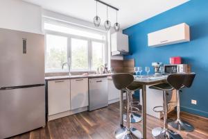 a kitchen with white appliances and blue walls at Résidence Sénac in Valenciennes