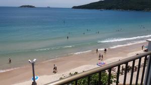 vistas a una playa con gente en el agua en Residencial Villa do Mar, en Florianópolis