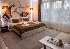 a bedroom with a large bed with two towels on it at Princ Apartment in Niš +113 photos