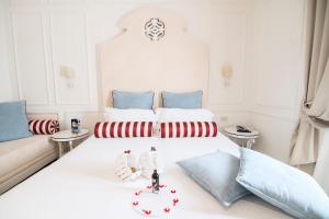 a bedroom with a white bed with red and blue pillows at Hotel Baglio Basile in Petrosino