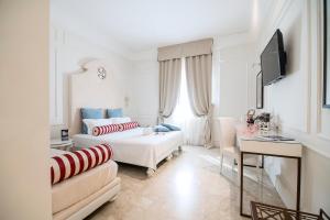 a white living room with a couch and a tv at Hotel Baglio Basile in Petrosino