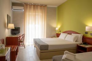 a hotel room with two beds and a television at Hotel Riva Del Sole in Giovinazzo