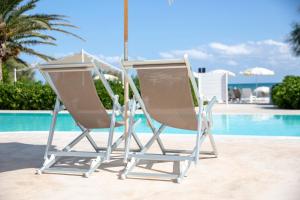 a white chair sitting in front of a pool of water at Hotel Riva Del Sole in Giovinazzo