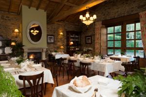 a dining room with tables and chairs and a fireplace at A Casa da Torre Branca in Santiago de Compostela