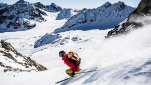 Ein Mann fährt einen schneebedeckten Berg hinunter in der Unterkunft Hotel Garni Romantika in Sankt Leonhard im Pitztal