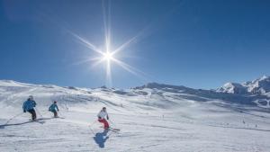 a group of three people skiing down a snow covered slope at Hotel Garni Romantika in Sankt Leonhard im Pitztal