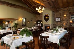 una sala da pranzo con tavoli con tovaglie bianche di A Casa da Torre Branca a Santiago de Compostela