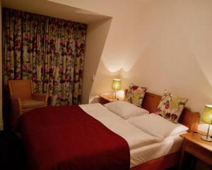 um quarto de hotel com uma cama com um cobertor vermelho em Appartementen de Strandloper em Bergen aan Zee