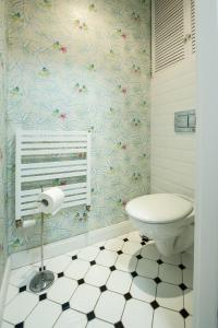 a bathroom with a toilet and a flower wallpaper at Cocorico Apartments in Poznań