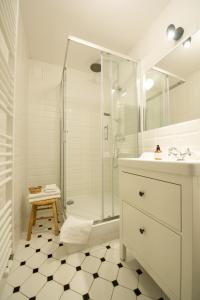 a white bathroom with a shower and a sink at Cocorico Apartments in Poznań