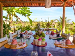a long table with plates of food on it at Pousada Recanto Beija-Flor Kitesurf in Fortim