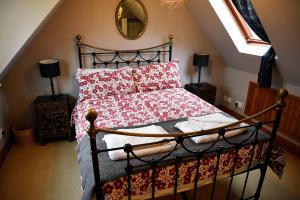 um quarto com uma cama com almofadas vermelhas e um espelho em The Old Inn, Staffin em Staffin