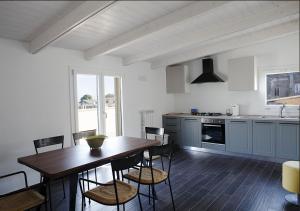 Il comprend une cuisine avec une table et des chaises en bois. dans l'établissement Attico e Suite Vistamare Vasto, à Vasto