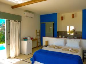 福廷的住宿－Pousada Recanto Beija-Flor Kitesurf，一间拥有蓝色墙壁和一张大床的卧室