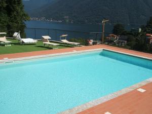 a large swimming pool with a view of the water at Green & Lake Home in Argegno