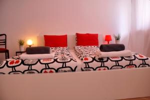 1 dormitorio con 1 cama con almohadas rojas en Apartament KoKi Retro, en Gdynia