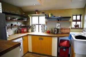 eine Küche mit Holzschränken und einem Fenster in der Unterkunft Quaraing House in Staffin + 7 Fotos