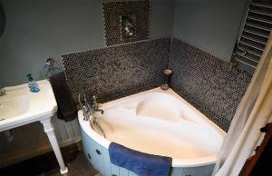 a bath tub in a bathroom next to a sink at Quaraing House in Staffin