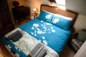 Un dormitorio con una cama azul con sábanas azules y blancas en Quaraing House, en Staffin