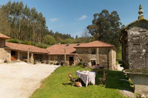 uma mesa e cadeiras em frente a uma casa de pedra em A Casa da Torre Branca em Santiago de Compostela