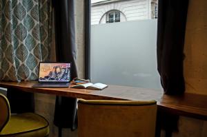 a laptop computer sitting on top of a wooden table at Loft Zen Rouen - Jacuzzi - Centre Historique in Rouen