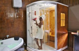 a woman standing in a shower in a bathroom at Maaha Beach Resort in Anochi