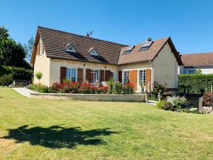 une maison avec une grande pelouse devant elle dans l'établissement En toute simplicité, à Lavilletertre