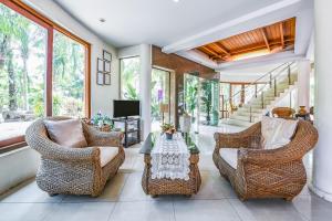 a living room with wicker chairs and a table at Suan Palm Garden View in Rayong