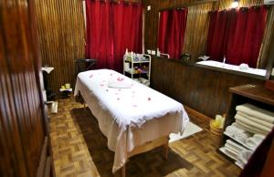 Zimmer mit einem Bett, einem Tisch und einem Spiegel in der Unterkunft Maaha Beach Resort in Anochi