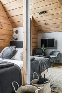 a bedroom with two beds and a flat screen tv at Sywarne Chalet in Kościelisko