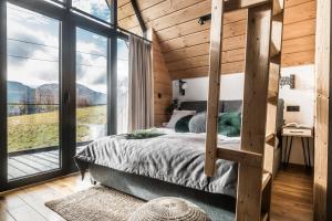a bedroom with a bed and a large window at Sywarne Chalet in Kościelisko