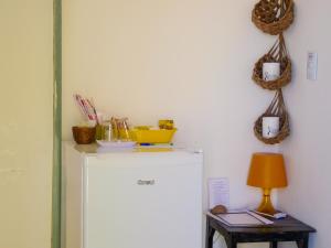 una nevera blanca en una habitación con una mesa y una lámpara en Pousada Recanto Beija-Flor Kitesurf en Fortim