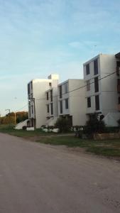 un grand bâtiment blanc au bord d'une rue dans l'établissement Miramar Panorámico, à Miramar